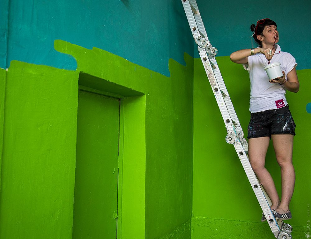 Аргентинка раскрашивает стены школы в Алматы 